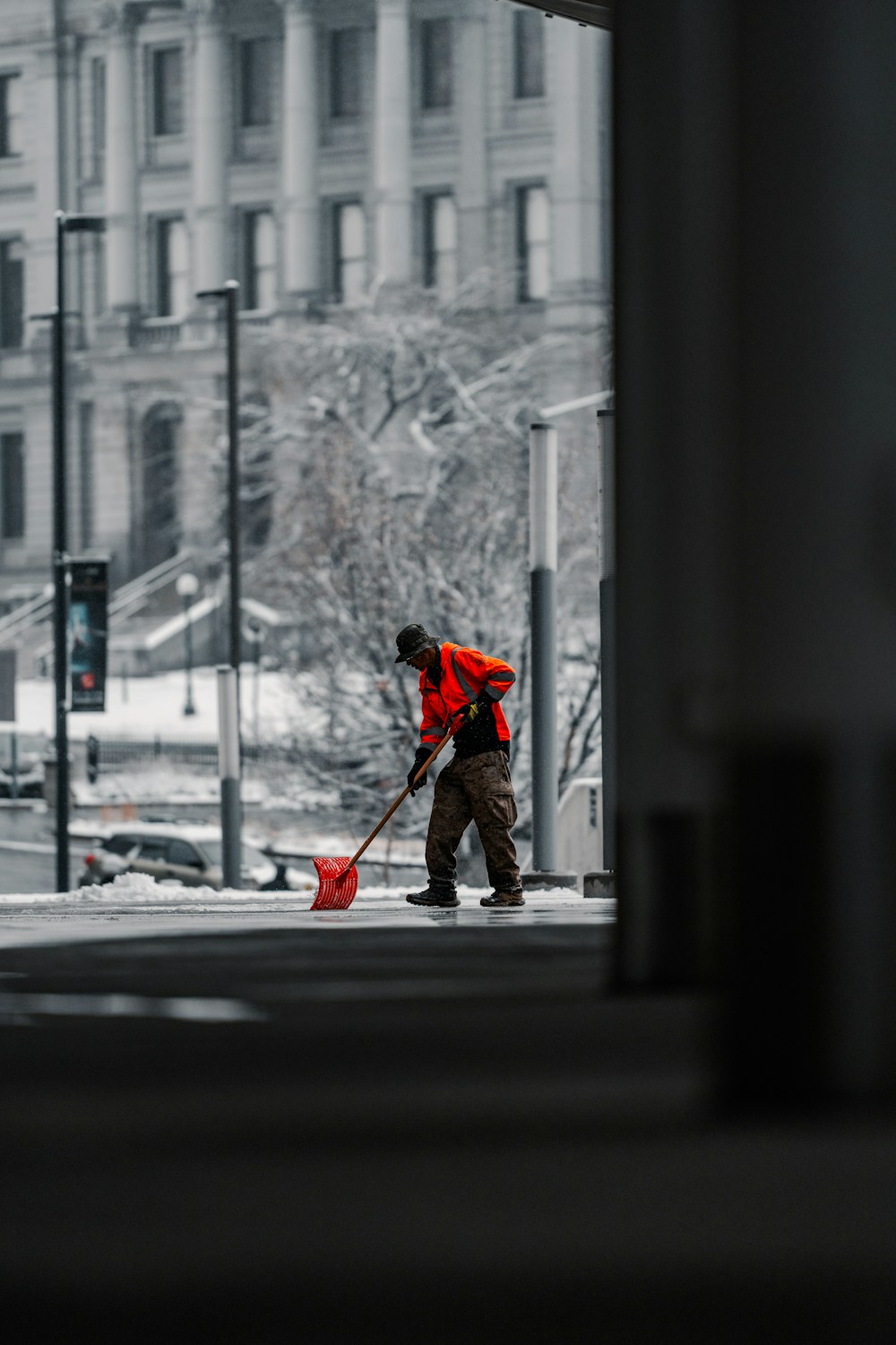 Schnee wird mit einer Schaufel vom Gehweg geräumt